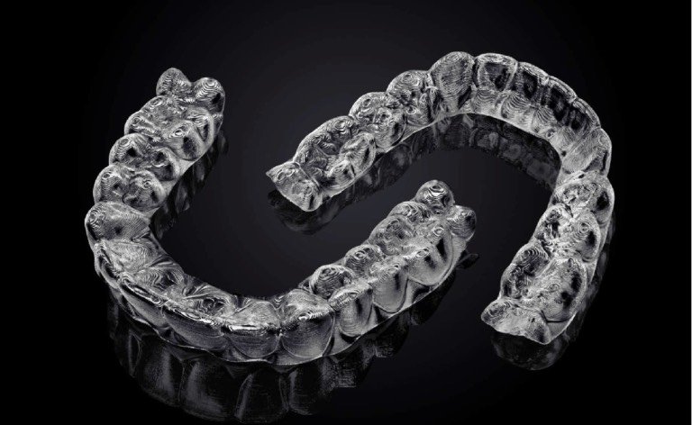 Custom-fabricated BPA-free clear aligner trays — virtually invisible when worn