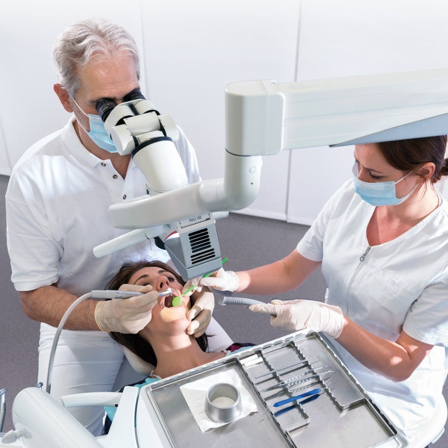 Microscope-guided treatment of a patient at 25× magnification